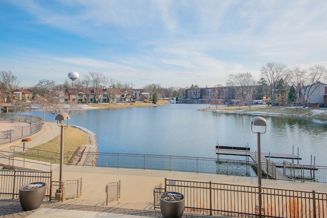 water view featuring a dock and fence