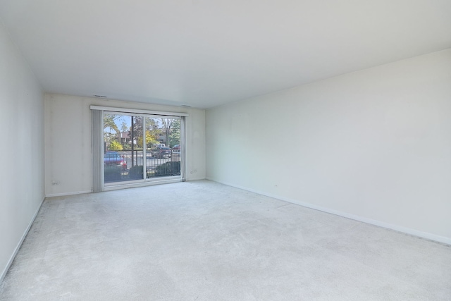 carpeted empty room with baseboards