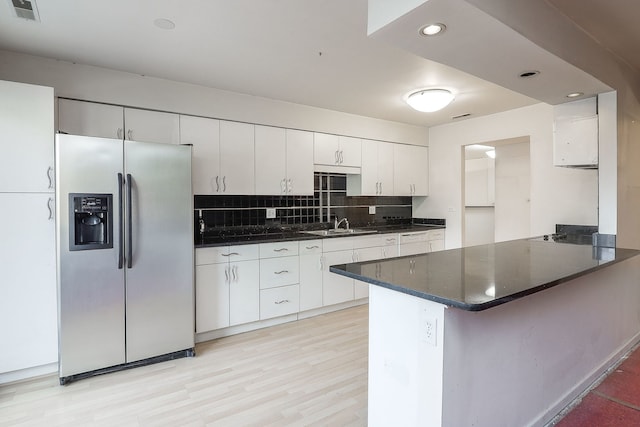 kitchen featuring dark countertops, stainless steel fridge, visible vents, and backsplash