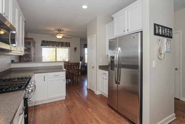 kitchen featuring hardwood / wood-style floors, appliances with stainless steel finishes, and white cabinetry