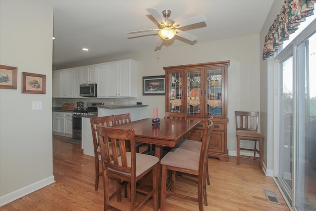 dining area with light wood-type flooring and ceiling fan