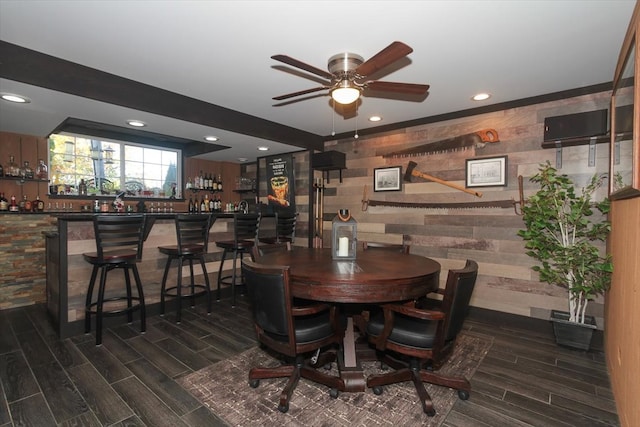 dining space with bar, ceiling fan, and dark hardwood / wood-style flooring