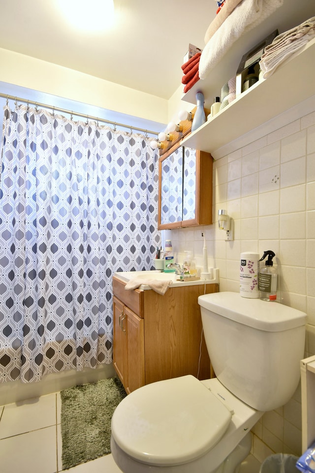 bathroom featuring vanity, toilet, and tile walls