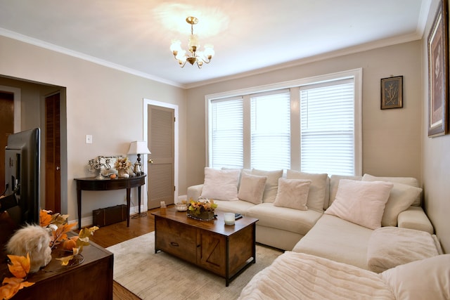 living room featuring an inviting chandelier, crown molding, and light wood-type flooring