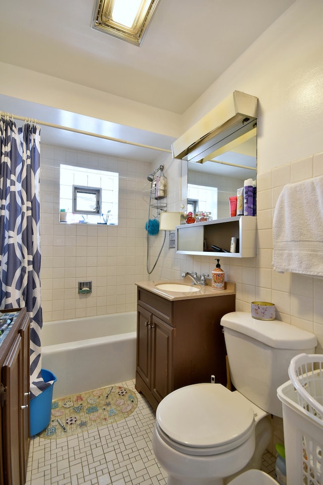 full bathroom with toilet, tasteful backsplash, vanity, and tile walls