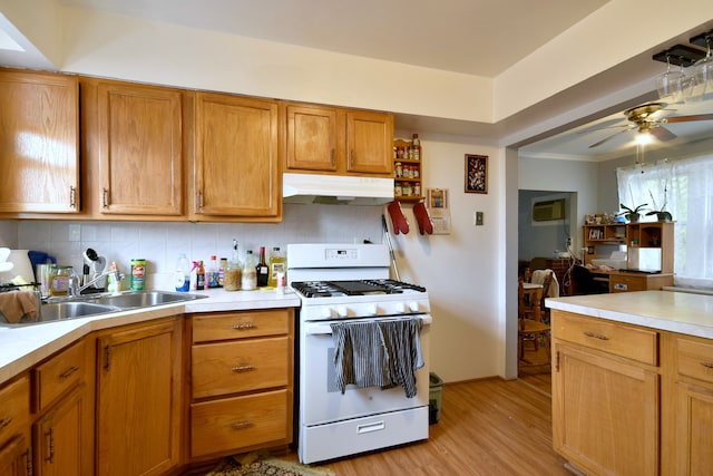 kitchen with tasteful backsplash, ceiling fan, light hardwood / wood-style floors, white range with gas stovetop, and sink