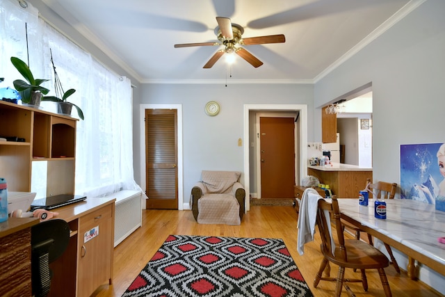 home office with crown molding, light hardwood / wood-style flooring, and ceiling fan