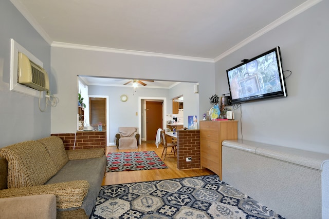 living room with a wall unit AC, light hardwood / wood-style flooring, ornamental molding, and ceiling fan