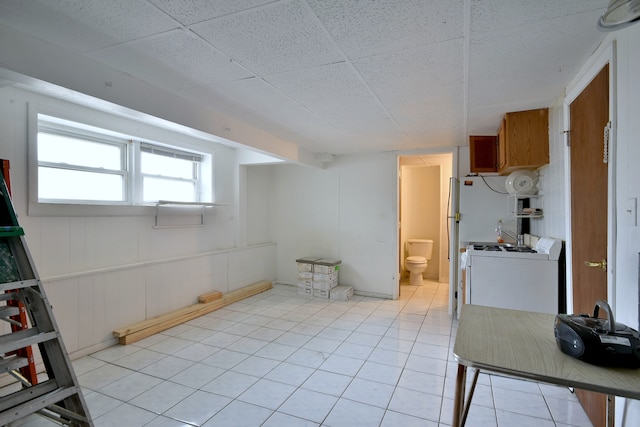 interior space featuring a paneled ceiling and light tile patterned floors