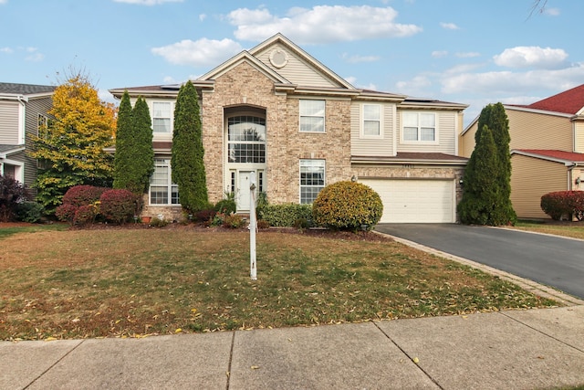 view of front of property featuring a front yard and a garage