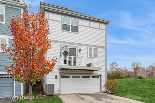 view of front of house featuring a garage, a balcony, and a front lawn