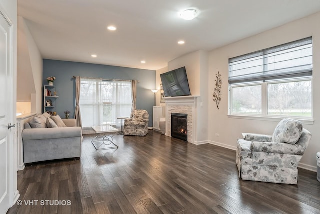 living room with a fireplace, dark hardwood / wood-style flooring, and plenty of natural light