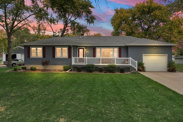 ranch-style home featuring a garage and a lawn