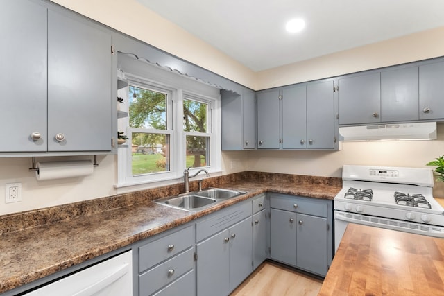 kitchen with white appliances, sink, light wood-type flooring, and gray cabinetry