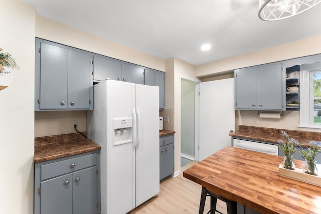 kitchen with light hardwood / wood-style flooring, gray cabinetry, and white appliances