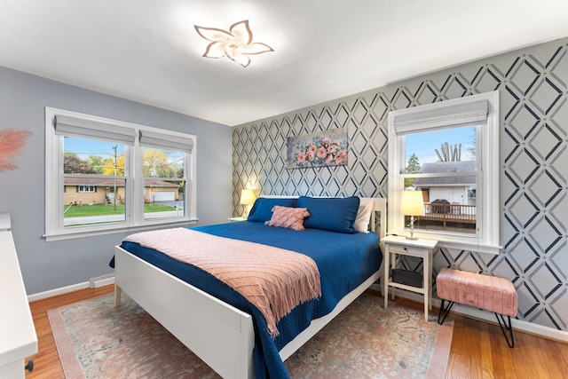 bedroom with a baseboard heating unit and hardwood / wood-style flooring