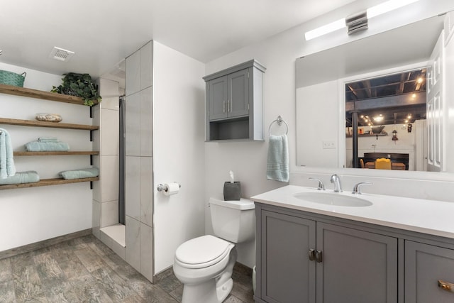 bathroom featuring toilet, hardwood / wood-style flooring, vanity, and a shower