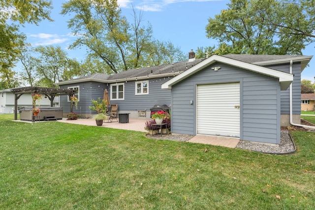 back of house with a hot tub, a patio area, and a lawn