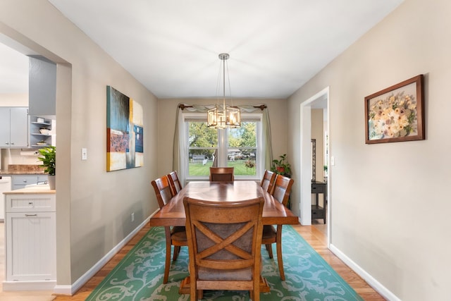 dining space featuring a notable chandelier and light wood-type flooring