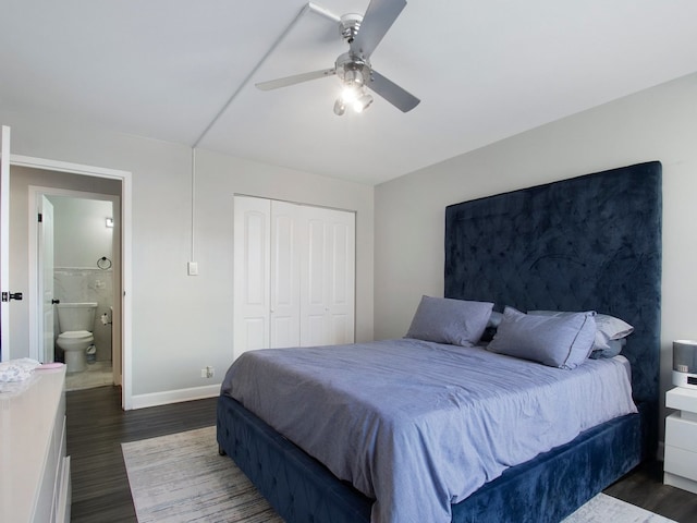 bedroom featuring a closet, ensuite bath, dark wood-type flooring, and ceiling fan