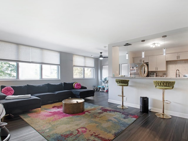 living room featuring dark hardwood / wood-style floors, sink, and ceiling fan