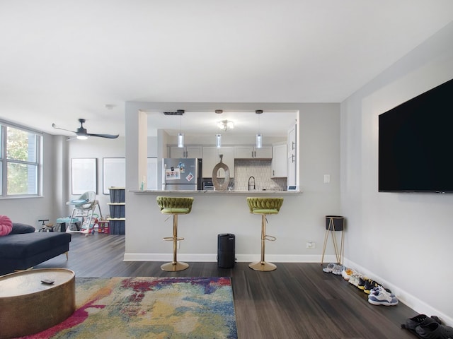 living room with sink, ceiling fan, and dark hardwood / wood-style flooring