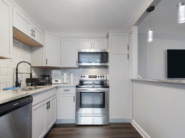 kitchen with backsplash, appliances with stainless steel finishes, dark hardwood / wood-style floors, and white cabinetry