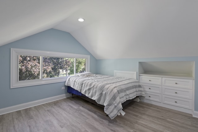 bedroom featuring lofted ceiling and light wood-type flooring