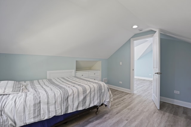 bedroom with lofted ceiling and light hardwood / wood-style flooring