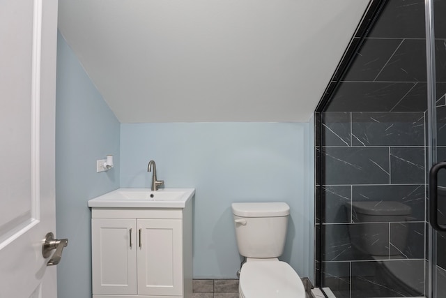 bathroom featuring toilet, a shower with door, vanity, and vaulted ceiling