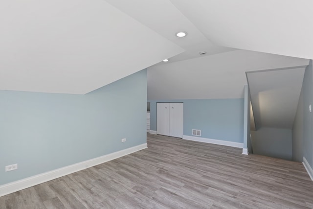 bonus room featuring vaulted ceiling and light wood-type flooring