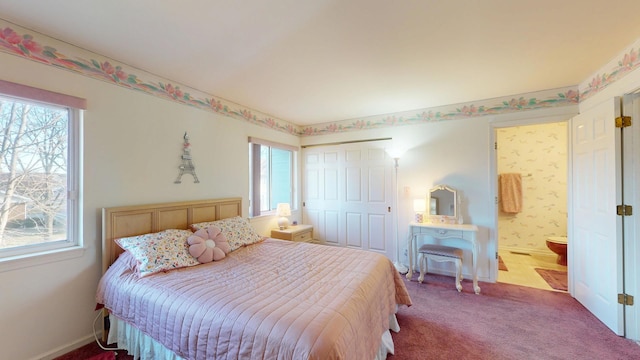 carpeted bedroom with multiple windows, ensuite bathroom, and a closet