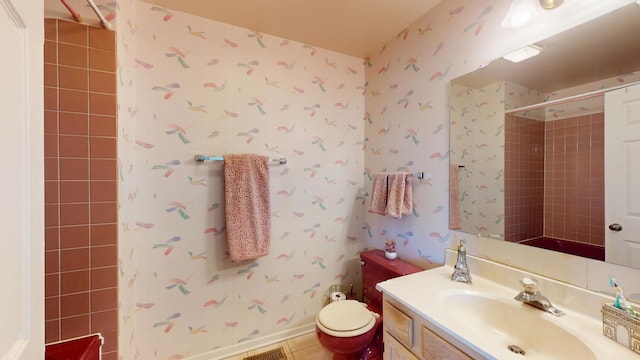 bathroom with vanity, tile patterned floors, toilet, and tiled shower