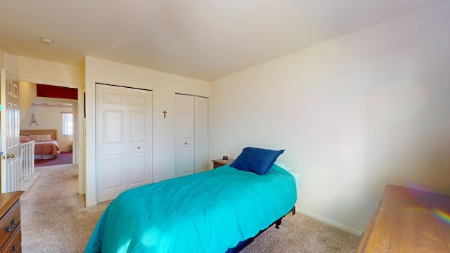 carpeted bedroom featuring multiple closets