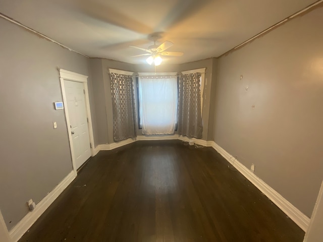 spare room with dark wood-type flooring and ceiling fan