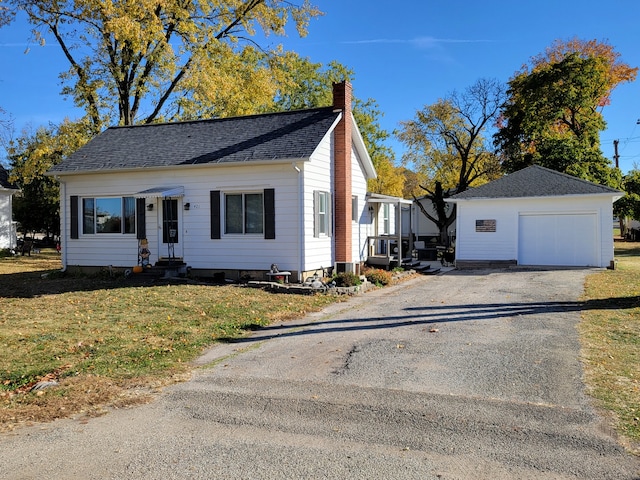 view of front facade with a front lawn, an outbuilding, and a garage