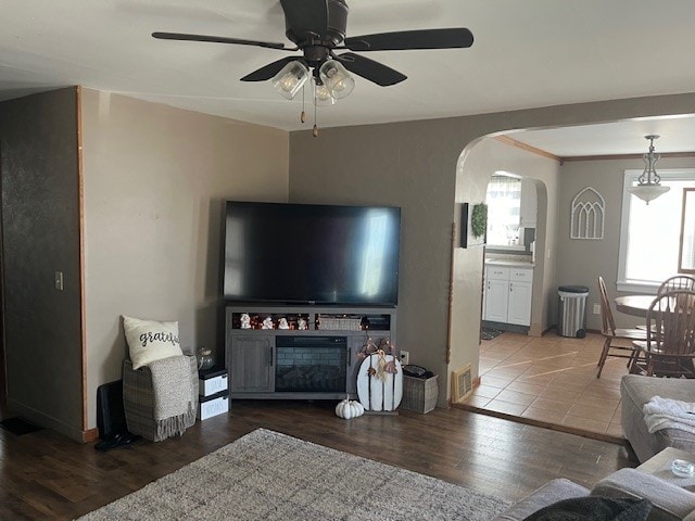 living room featuring ceiling fan, crown molding, and hardwood / wood-style floors