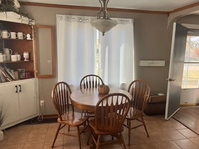 tiled dining area featuring crown molding