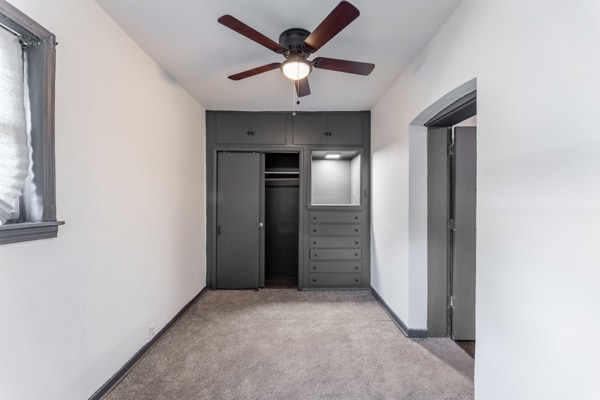 unfurnished bedroom featuring a closet, ceiling fan, and light carpet