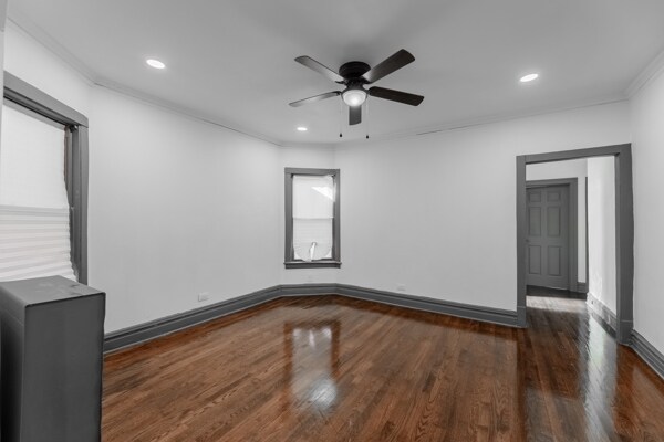 spare room with ornamental molding, ceiling fan, and dark hardwood / wood-style flooring