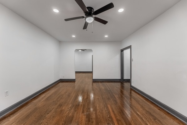 spare room with dark wood-type flooring and ceiling fan