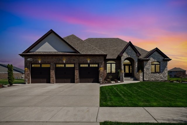 view of front facade with a yard and a garage