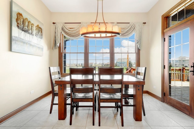 tiled dining space featuring a notable chandelier and a healthy amount of sunlight