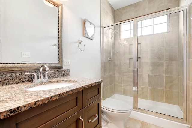 bathroom with vanity, a shower with shower door, toilet, and tile patterned flooring