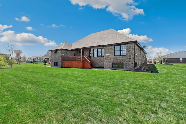 rear view of house featuring a wooden deck and a lawn