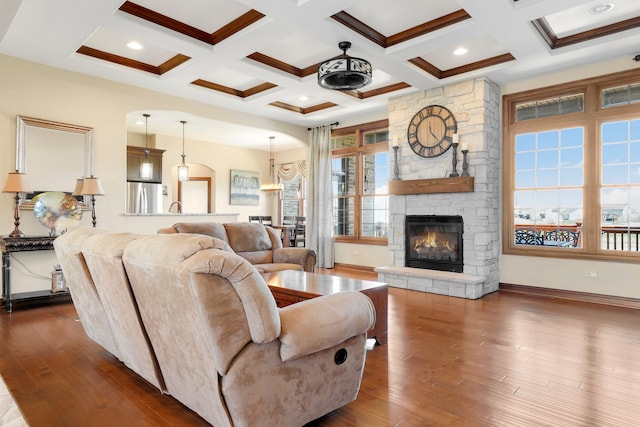 living room with a healthy amount of sunlight, beamed ceiling, and dark wood-type flooring