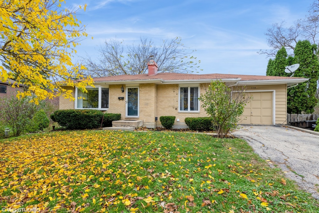 ranch-style house with a garage and a front lawn