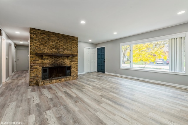 unfurnished living room with a fireplace and light hardwood / wood-style floors