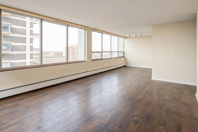 spare room with a baseboard radiator and dark hardwood / wood-style floors