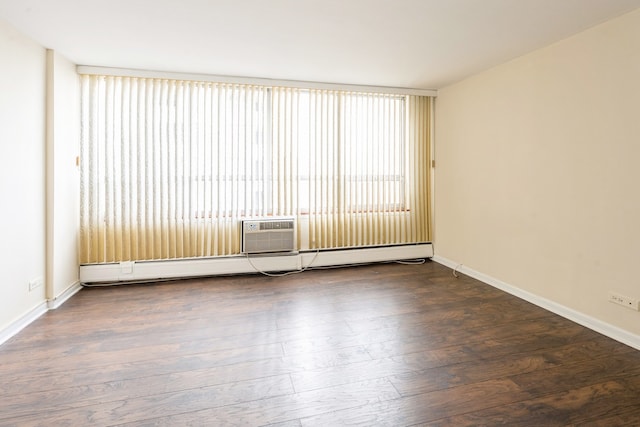 unfurnished room with dark hardwood / wood-style flooring and a baseboard heating unit